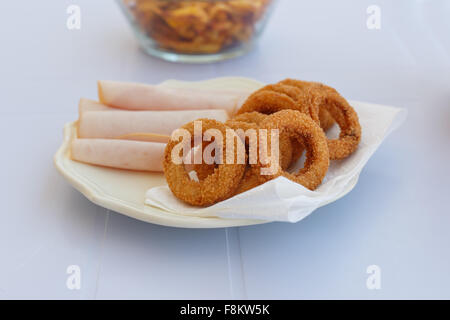 Close up en détail vue avant d'une plaque de base de l'oignon frit avec jambon servi sur une assiette. Banque D'Images