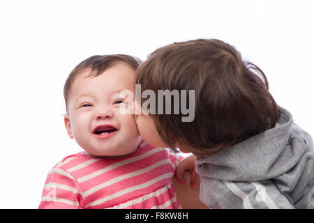 Un portrait d'un mignon et affectueux frère et sœur sur un fond blanc. Banque D'Images