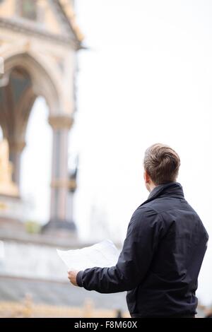 Jeune homme à la carte la recherche jusqu'à l'Albert Memorial, London, England, UK Banque D'Images