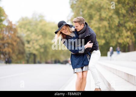 Jeune couple romantique fricoter dans Park, London, England, UK Banque D'Images