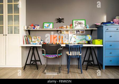 Violon, globe, de peintures et de livres sur les étagères et bureau de childs Banque D'Images