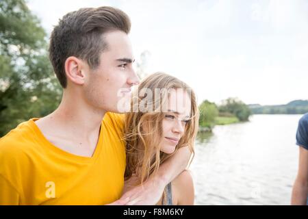 Jeune couple à côté du lac, looking at view Banque D'Images