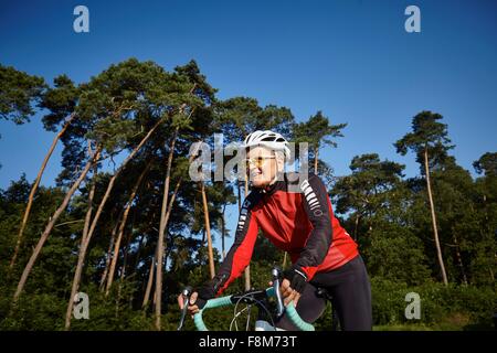 Équitation forêt passé cycliste mature Banque D'Images