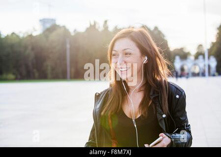 Mid adult woman wearing earphones Banque D'Images