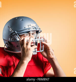 Image composite de l'agressivité american football player holding helmet Banque D'Images