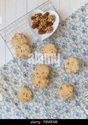 L'érable, le noyer et le pacanier Cookies sur une plaque de cuisson, les noix dans un bol en forme de coeur. Banque D'Images