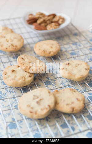 L'érable, le noyer et le pacanier Cookies sur une plaque de cuisson, les noix dans un bol en forme de coeur. Banque D'Images