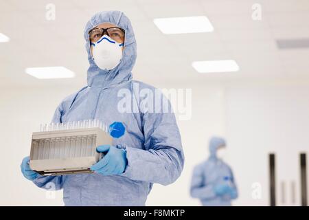 Scientist carrying tray of test tubes in laboratory Banque D'Images