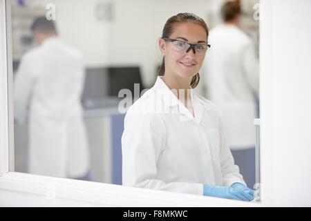Scientist in laboratory, des collègues qui travaillent en arrière-plan Banque D'Images