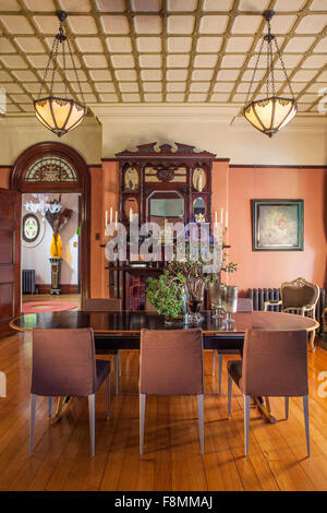 La maison d'Erica designer pols. La salle à manger. Table et chaises, et un grand buffet avec overmantle. Une case cochée sur le plafond, et du parquet ciré. Style Victorien traditionnel. Banque D'Images