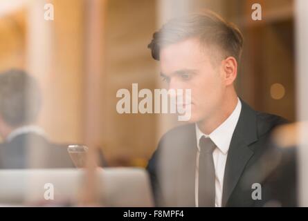 Businessman working on laptop in cafe Banque D'Images