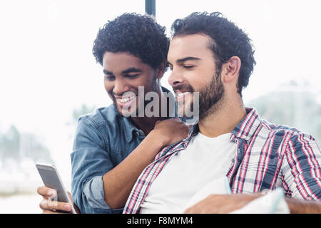 Happy gay couple using smartphone Banque D'Images