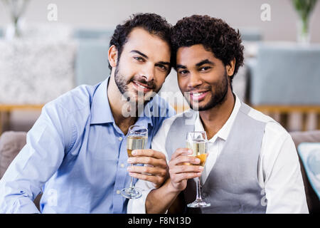 Happy gay couple drinking champagne Banque D'Images