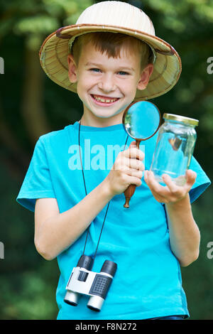 Boy Studying Jar Papillon pris dans Banque D'Images