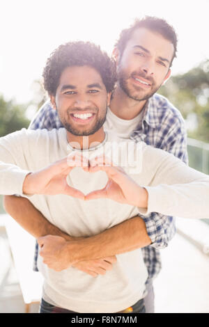 Happy gay couple hugging outdoors Banque D'Images