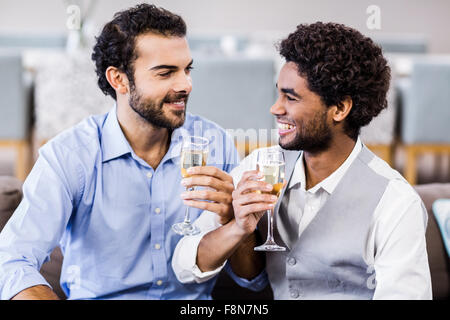 Happy gay couple drinking champagne Banque D'Images