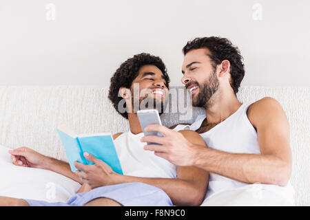 Happy gay couple talking on bed Banque D'Images