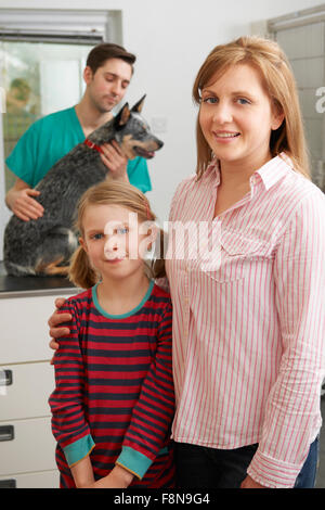 Mère et fille en tenant à l'examen de chien vétérinaires Banque D'Images