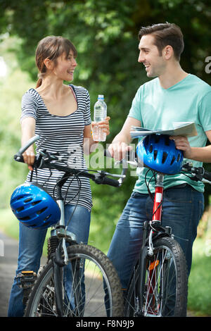 Young Couple Having Break alors que sur les pays Cycle Ride Banque D'Images