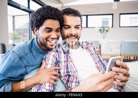 Happy gay couple using smartphone Banque D'Images