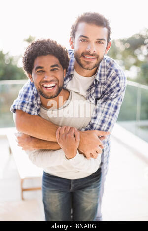 Happy gay couple hugging outdoors Banque D'Images