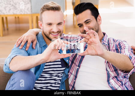 Couple Gay de détente sur le canapé en prenant selfies Banque D'Images