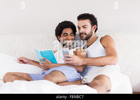 Heureux couple gay sur lit ensemble Banque D'Images