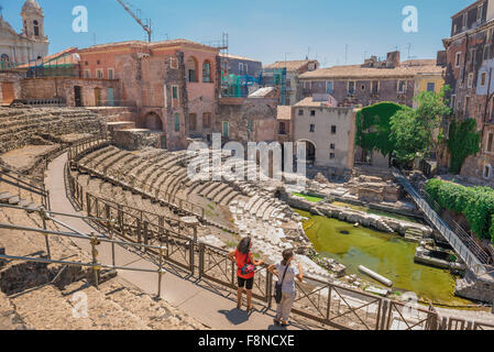 Théâtre romain de Catane, vue arrière de deux touristes dans l'ancien théâtre romain, le théâtre romain, dans le centre de la ville de Catane, Sicile. Banque D'Images