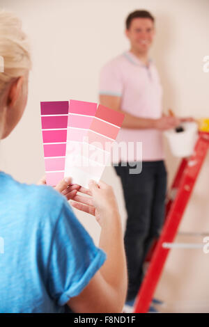 Jeune couple Looking At Paint Swatches In New Home Banque D'Images