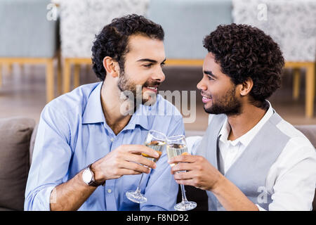 Happy gay couple drinking champagne Banque D'Images