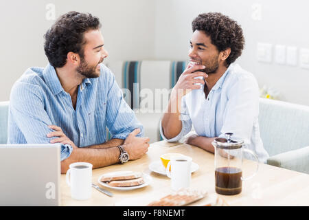Heureux couple gay, le petit-déjeuner et parler Banque D'Images
