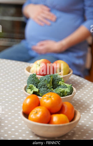 Pregnant Woman Looking At bols de fruits et légumes sains Banque D'Images