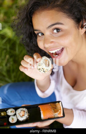 Young Woman Enjoying Déjeuner Sushi à emporter Banque D'Images