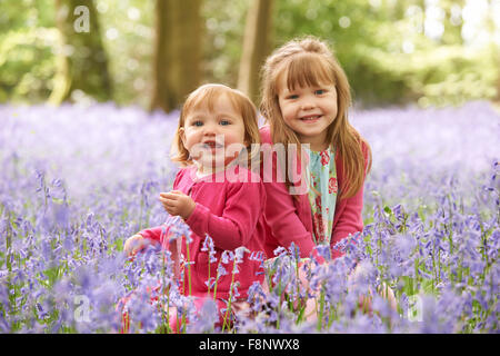 Deux jeunes filles en séance ensemble Bois Bluebell Banque D'Images