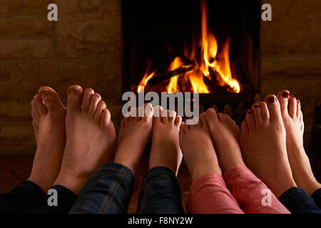 Réchauffement de la famille par le feu les pieds Banque D'Images