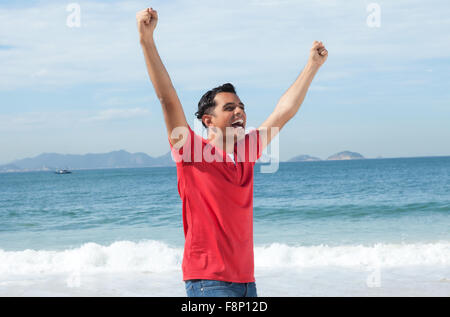 Rire Amérique guy cheering at beach Banque D'Images