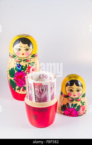 Rouleau de 50 £ Livre sterling note caché dans matriochka poupée russe. Banque D'Images