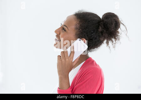 Un jeune afro-américaines ou mixed race woman chatting on smartphone Banque D'Images