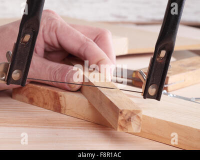 Close-up de la main de l'homme méconnaissable.planche en bois de sciage Banque D'Images