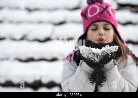 Girl blowing poignée de neige Banque D'Images