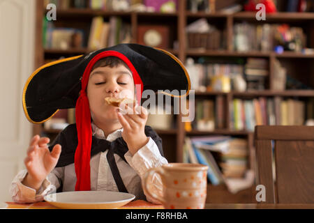 Jeune garçon déguisé en pirate eating sandwich Banque D'Images