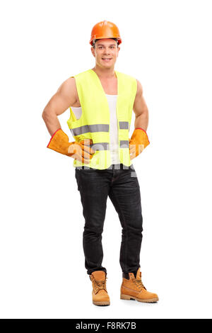 Portrait d'un jeune travailleur de la construction avec une orange casque et un gilet réfléchissant vert Banque D'Images