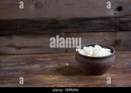 Le fromage cottage culinaires dans une cuvette d'argile sur table en bois foncé Banque D'Images