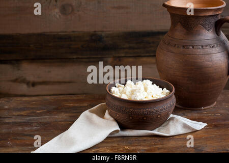 Le fromage cottage culinaires dans une cuvette d'argile sur table en bois foncé Banque D'Images