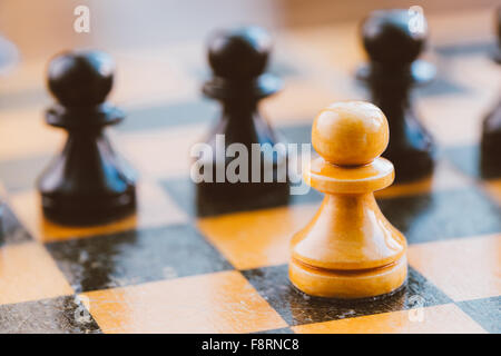 Blanc et noir vieux pions d'échecs debout sur échiquier vintage Banque D'Images