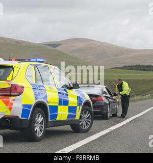 Automobiliste intercepté par le côté de l'autoroute M74 en direction sud par un agent de police dans l'auto-patrouille - Écosse, Royaume-Uni Banque D'Images