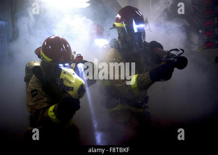 Dommage Controlman 3 classe R. Berens, dommage Controlman gauche, et D. Barber lutter contre un incendie simulé au cours d'un exercice à bord du porte-avions USS Harry S. Truman Banque D'Images