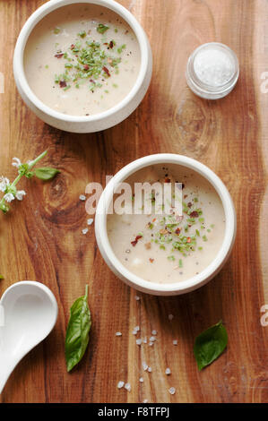 Soupe de crème sur un fond de bois avec le basilic et les herbes Banque D'Images