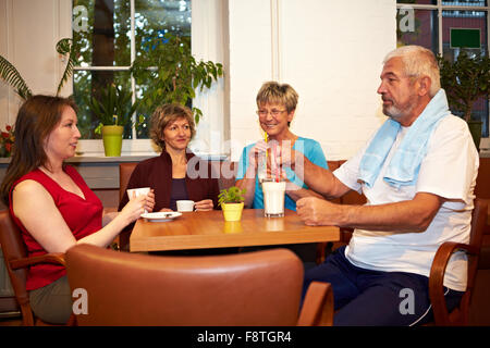 Groupe mixte de boire du café dans une salle de sport Banque D'Images