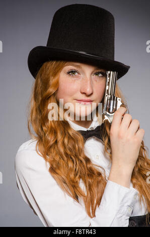 Pretty girl wearing hat rétro et la tenue d'arme isolé sur gray Banque D'Images